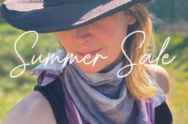 Tabitha wears a black cowboy hat with a feather in it and a kneckercheif around her neck to complete the look