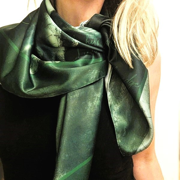 Model wears a Scandalous scarf in green 'Watch Me' draped around her neck  - she looks sophisticated and chic in this silky scarf for women and art lovers